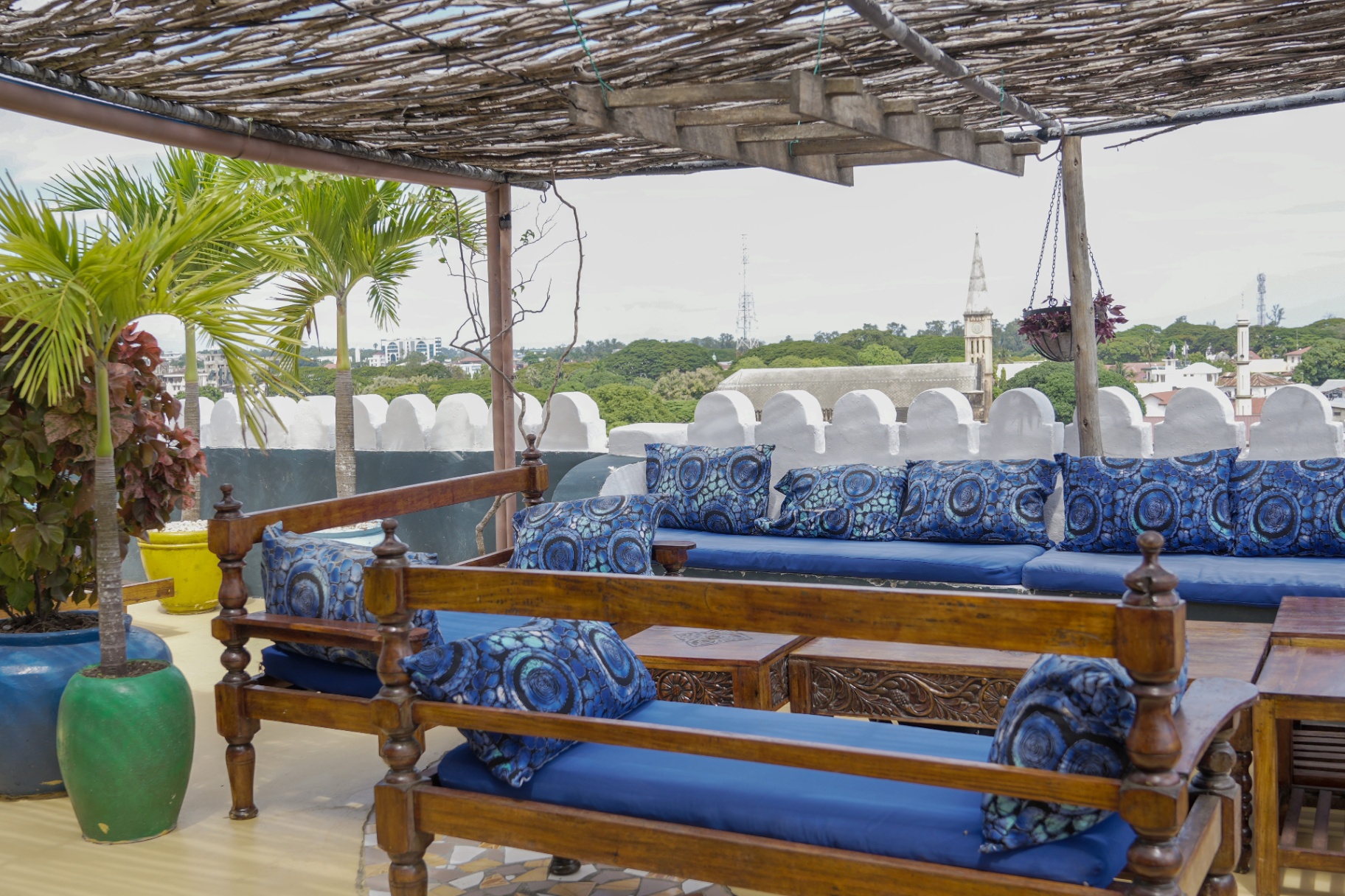 A Swahili rooftop terrace above the Stone Town rooftops, set with indigo cushions and looking towards the ocean
